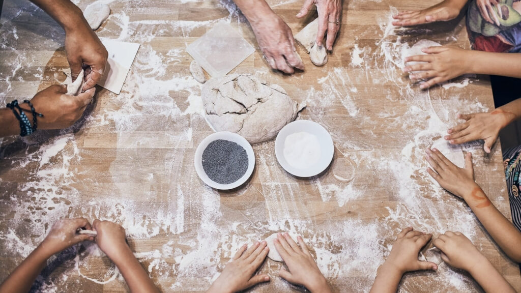 mãos fazendo pão em casa